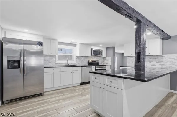 a kitchen with stainless steel appliances granite countertop a refrigerator sink and microwave