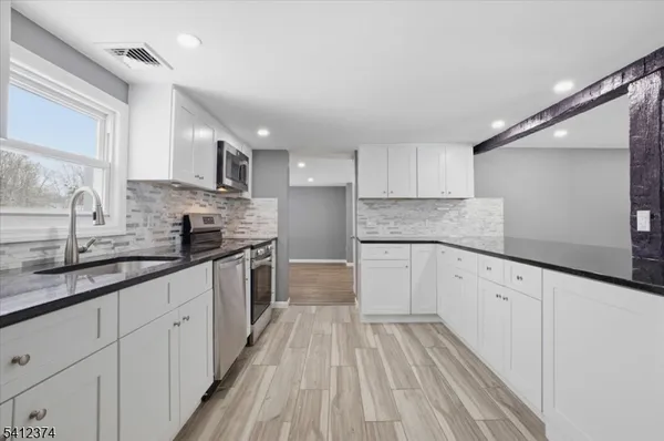 a kitchen with granite countertop white cabinets and white appliances