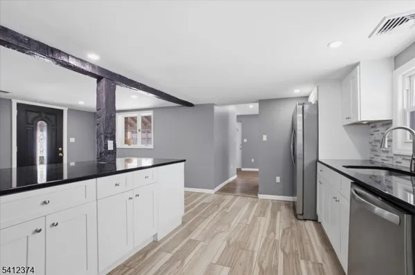 a spacious bathroom with a granite countertop sink a toilet a mirror and shower