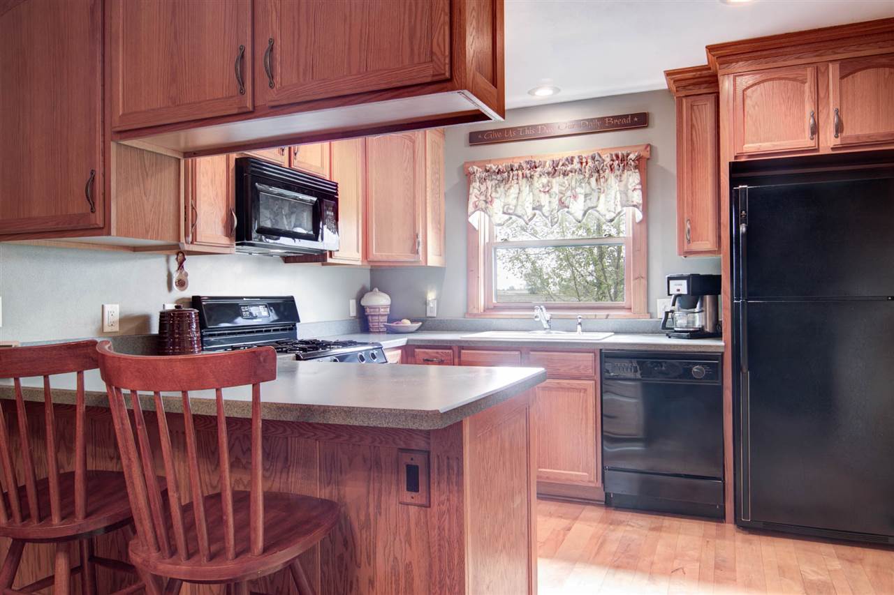 15232 Kelley Road Pecatonica, IL 61063 - Photo 9 of 24 a kitchen with stainless steel appliances a stove a sink and a microwave