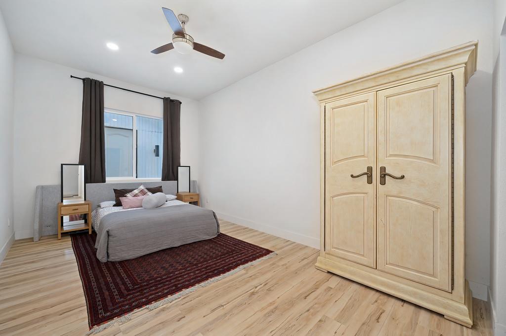 7011 Kemper Road Oakdale, CA 95361 - Photo 23 of 50 a bedroom with a bed and wooden floor