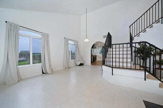 a living room with furniture potted plant and a large window
