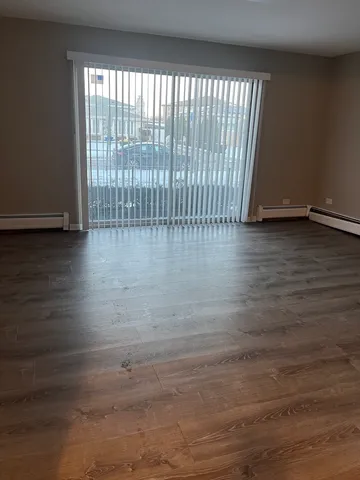 en empty room with wooden floor and windows