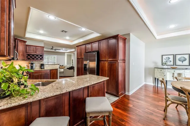 a kitchen with stainless steel appliances granite countertop a table chairs sink and cabinets