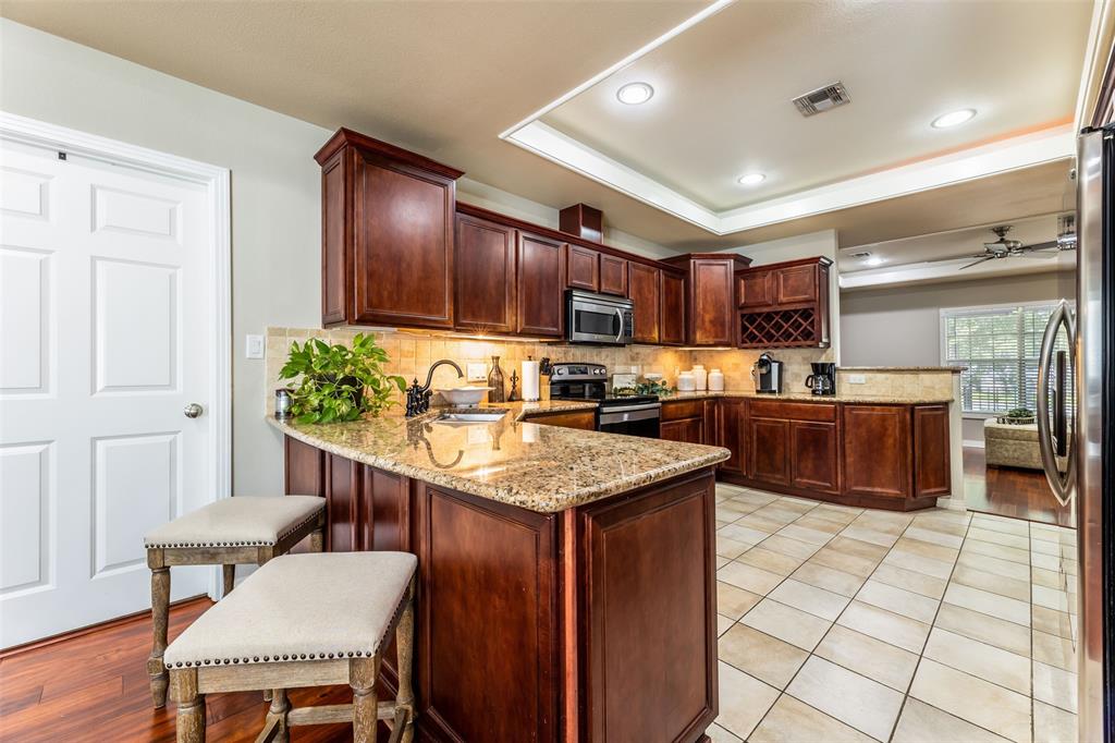 608 East 13th Street Georgetown, TX 78626 - Photo 8 of 22 a kitchen with stainless steel appliances granite countertop a table chairs sink and cabinets