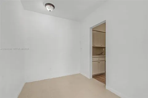 a hallway with white cabinets and sink