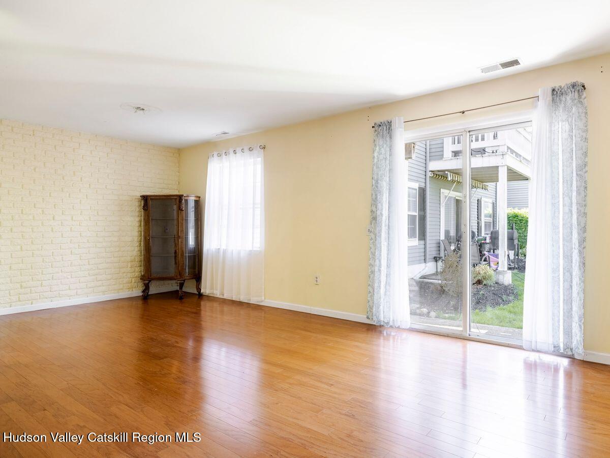 902 Commons Way, Unit B Fishkill, NY 12524 - Photo 13 of 24 a view of an empty room with wooden floor and a window