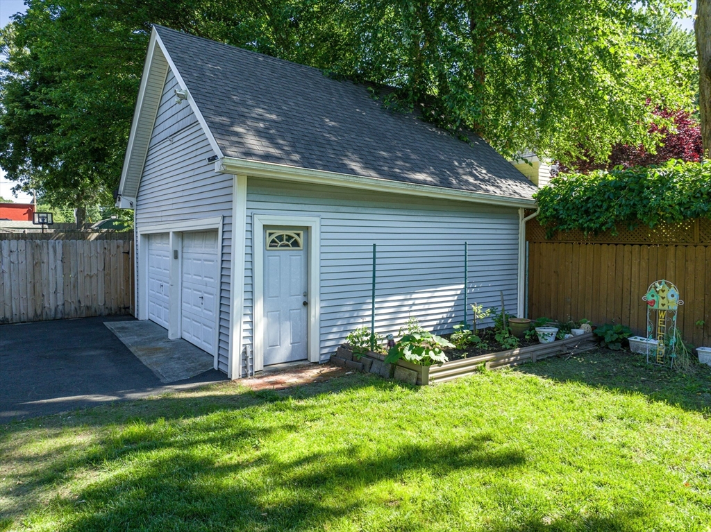 27 Powell Avenue Springfield, MA 01118 - Photo 25 of 34 a backyard of a house with plants and large tree