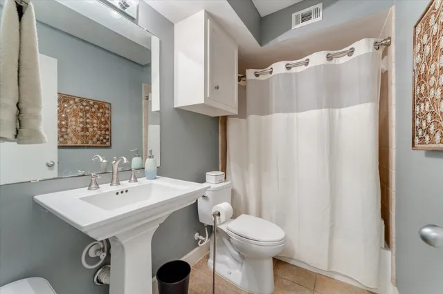 a bathroom with a sink a toilet and shower curtain