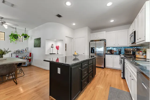 a kitchen with stainless steel appliances granite countertop a stove top oven a sink dishwasher and a refrigerator