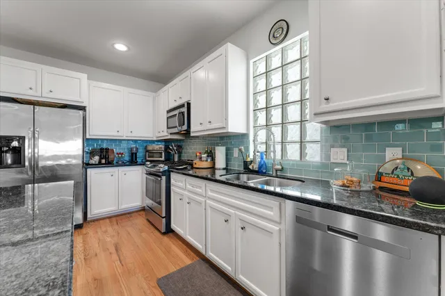 a kitchen with granite countertop stainless steel appliances a sink a counter space and cabinets