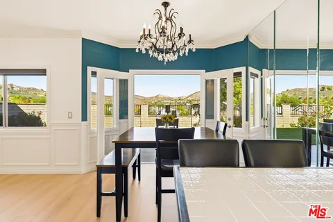 a view of a dining room with furniture large windows and wooden floor