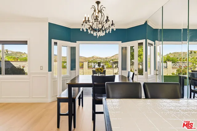 a view of a dining room with furniture large windows and wooden floor