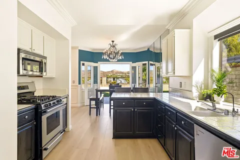 a kitchen with stainless steel appliances kitchen island granite countertop a stove a sink and a microwave