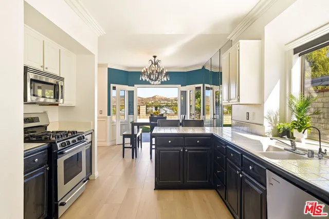 a kitchen with stainless steel appliances kitchen island granite countertop a stove a sink and a microwave
