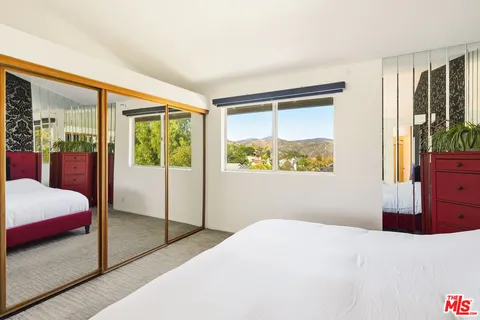 a bedroom with a bed and glass windows