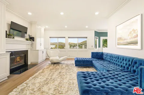 a living room with a couch a flat screen tv and a fireplace
