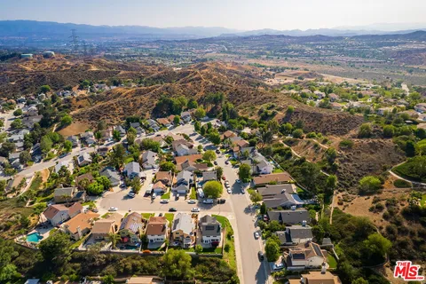 an aerial view of residential houses with outdoor space and trees