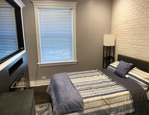 a bedroom with a bed tv and a window