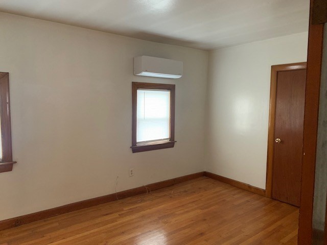 an empty room with wooden floor and a window