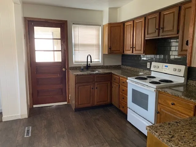 a kitchen with stainless steel appliances granite countertop a stove a sink and a microwave