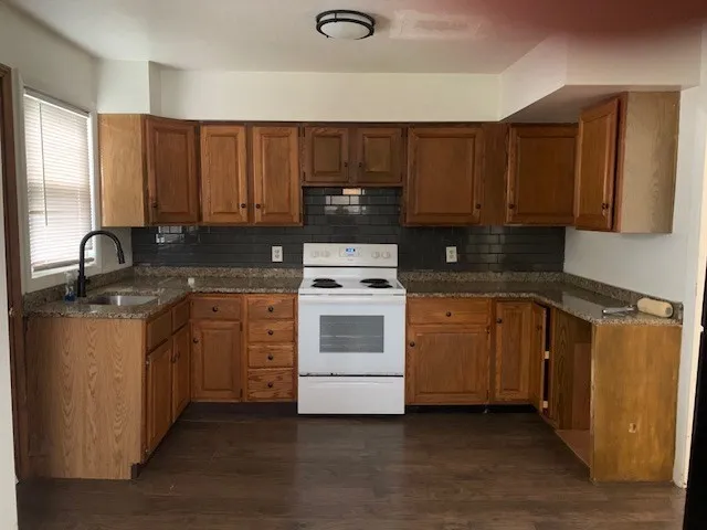 a kitchen with a sink stove and cabinets