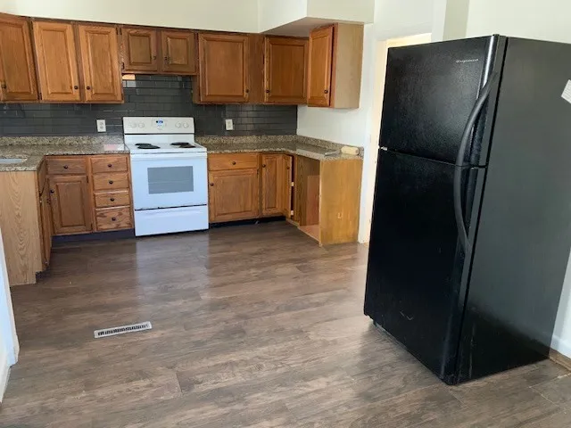 a kitchen with a refrigerator and a stove