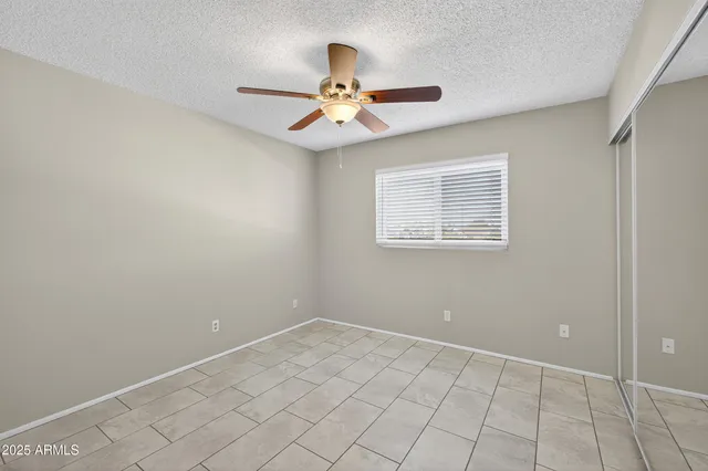 an empty room with windows and fan