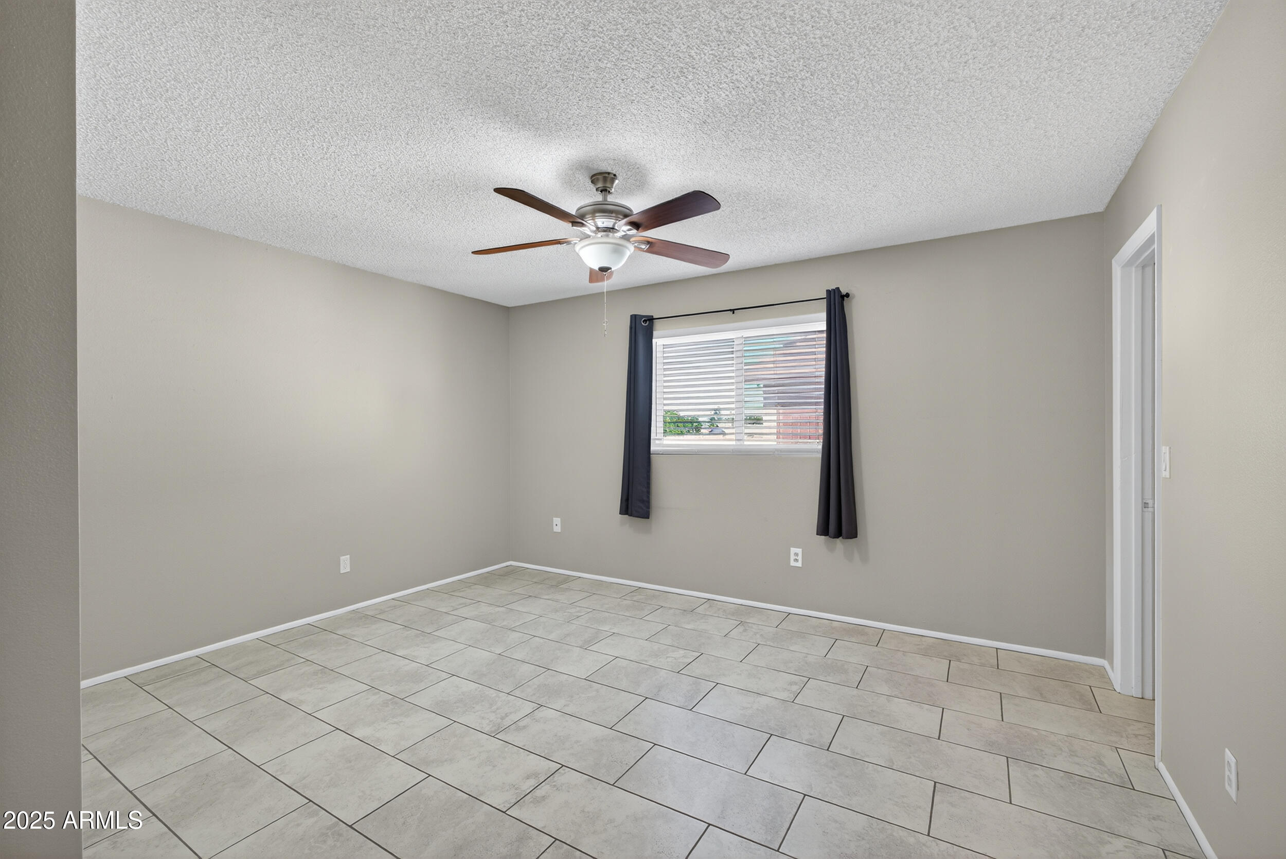 860 East Brown Road, Unit 67 Mesa, AZ 85203 - Photo 18 of 27 an empty room with windows and fan