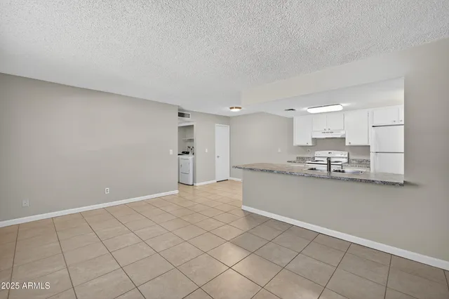 a large white kitchen with cabinets
