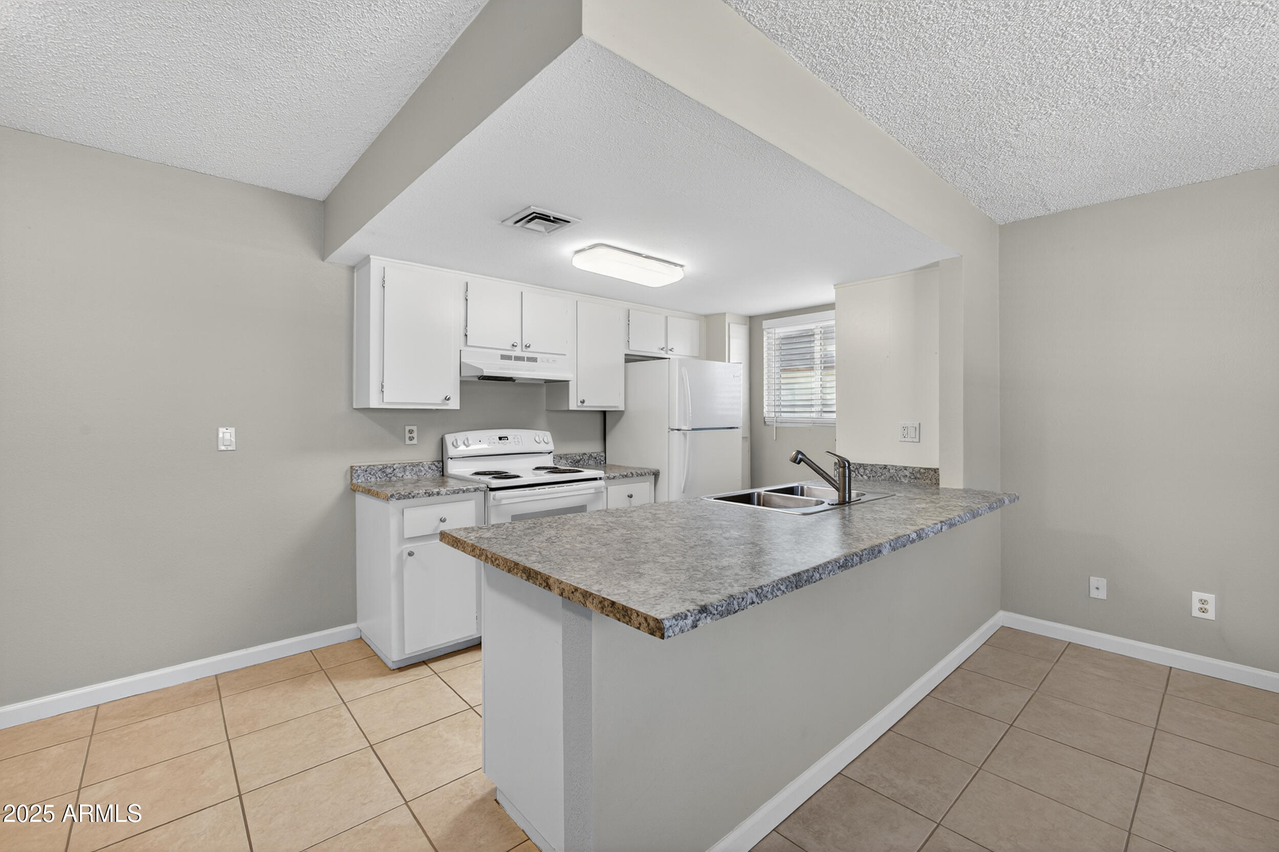 860 East Brown Road, Unit 67 Mesa, AZ 85203 - Photo 7 of 27 a kitchen with stainless steel appliances granite countertop a sink stove and cabinets