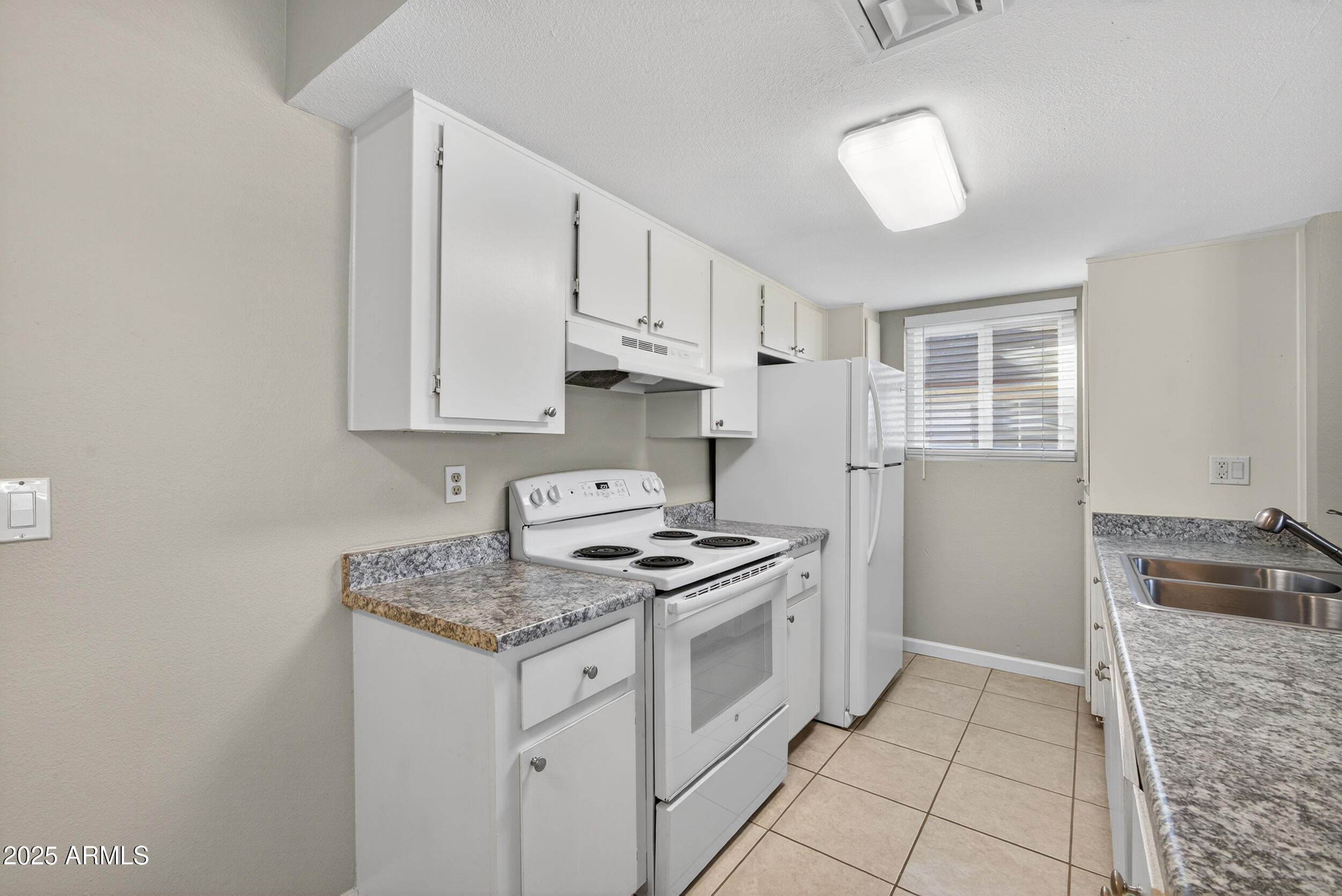 860 East Brown Road, Unit 67 Mesa, AZ 85203 - Photo 8 of 27 a kitchen with granite countertop a sink stove and cabinets
