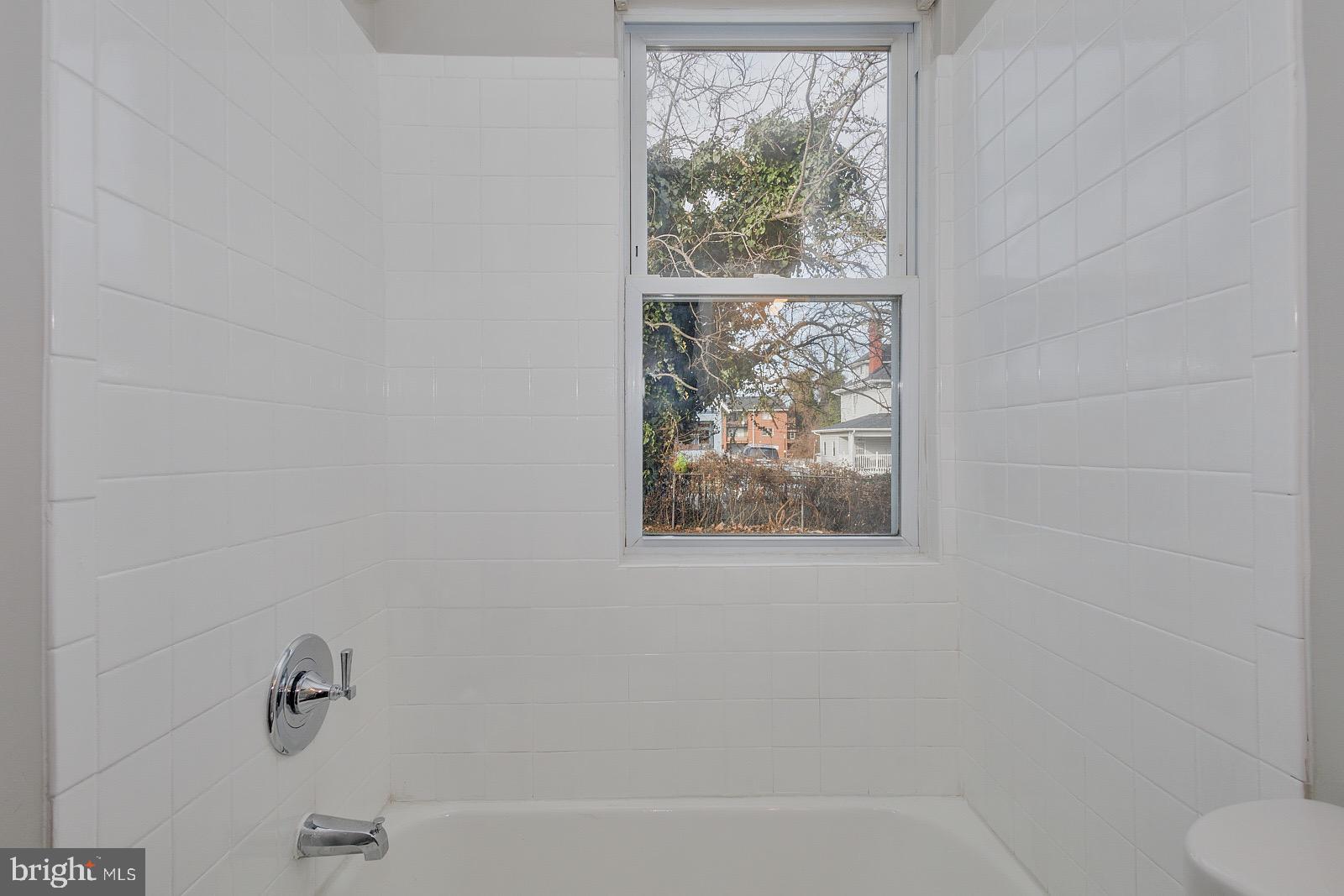 3407 Elgin Avenue, Unit 1 Baltimore, MD 21216 - Photo 12 of 15 a bathroom with a bathtub and window