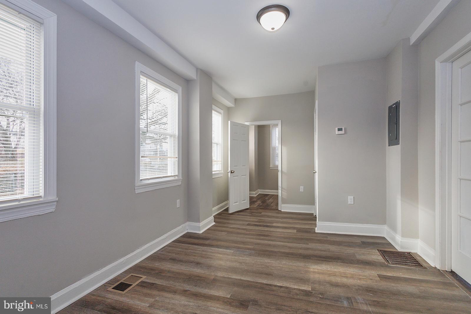 3407 Elgin Avenue, Unit 1 Baltimore, MD 21216 - Photo 14 of 15 a view of an empty room with wooden floor and a window