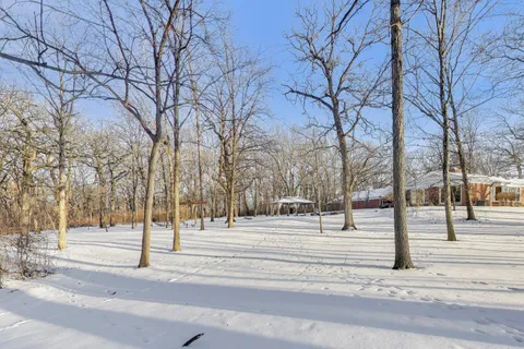 a view of empty room with wooden floor and fireplace
