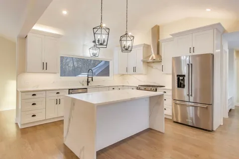a kitchen with stainless steel appliances a sink stove and refrigerator