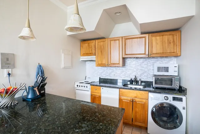 a kitchen with stainless steel appliances granite countertop a sink a stove and a wooden floors