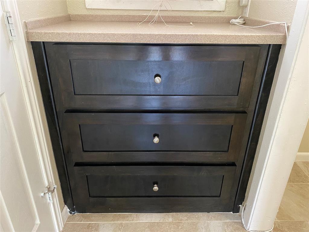 2402 Rio Grande Street, Unit 4 Austin, TX 78705 - Photo 1 of 5 Built-in cabinetry with three deep drawers, dark wood-finish paneling, and brushed nickel hardware