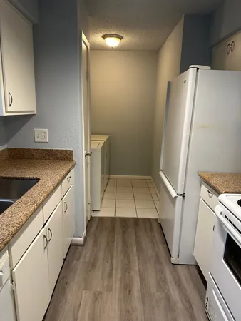 a kitchen with a sink a refrigerator a washer and dryer