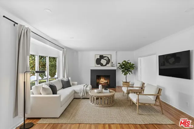 a living room with furniture a flat screen tv and a fireplace