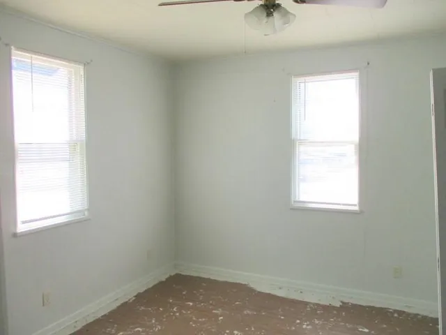 a view of a room that has a window and furniture