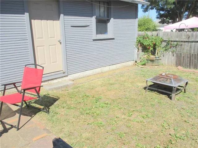 a backyard of a house with table and chairs