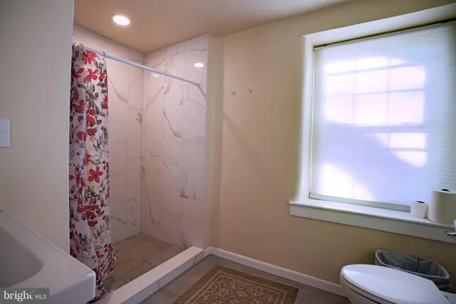 a bathroom with a shower curtain and a window