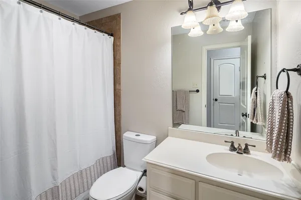 a bathroom with a sink vanity mirror and toilet