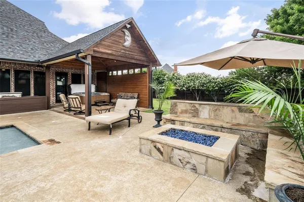 a view of a patio with a table and chairs under an umbrella