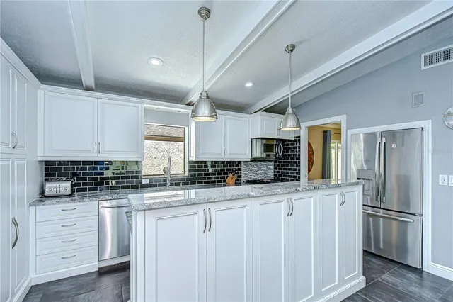 a view of a dining room kitchen with furniture and chandelier
