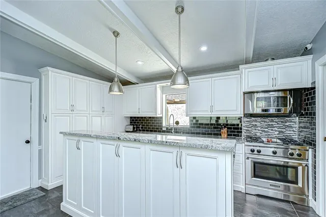 a view of a dining room with furniture a chandelier and large window