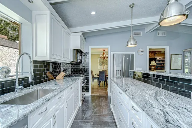 a dining room with wooden floor a chandelier a wooden table and chairs