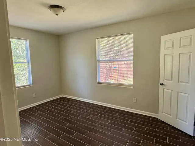 a view of a livingroom with wooden floor and a window