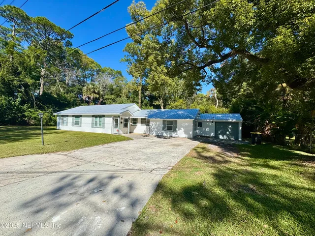 a view of house with yard and swimming pool
